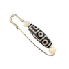 Gold-tone safety pin brooch with a black and white Nine-Eye Dzi bead center.