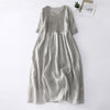Beige accordion pleat V-neck short sleeve midi dress laid flat on white background