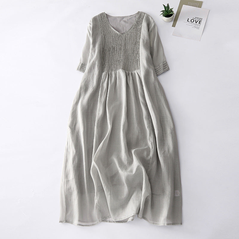 Beige accordion pleat V-neck short sleeve midi dress laid flat on white background