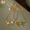 Gold plated sterling silver bracelet with two fox charms holding white or green stones