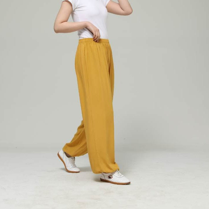 Model wearing loose yellow cotton pants with elastic waist