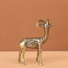 Small brass goat figurine standing on a wooden surface