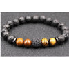 Close up of a bracelet with black lava rock beads and tiger eye stones