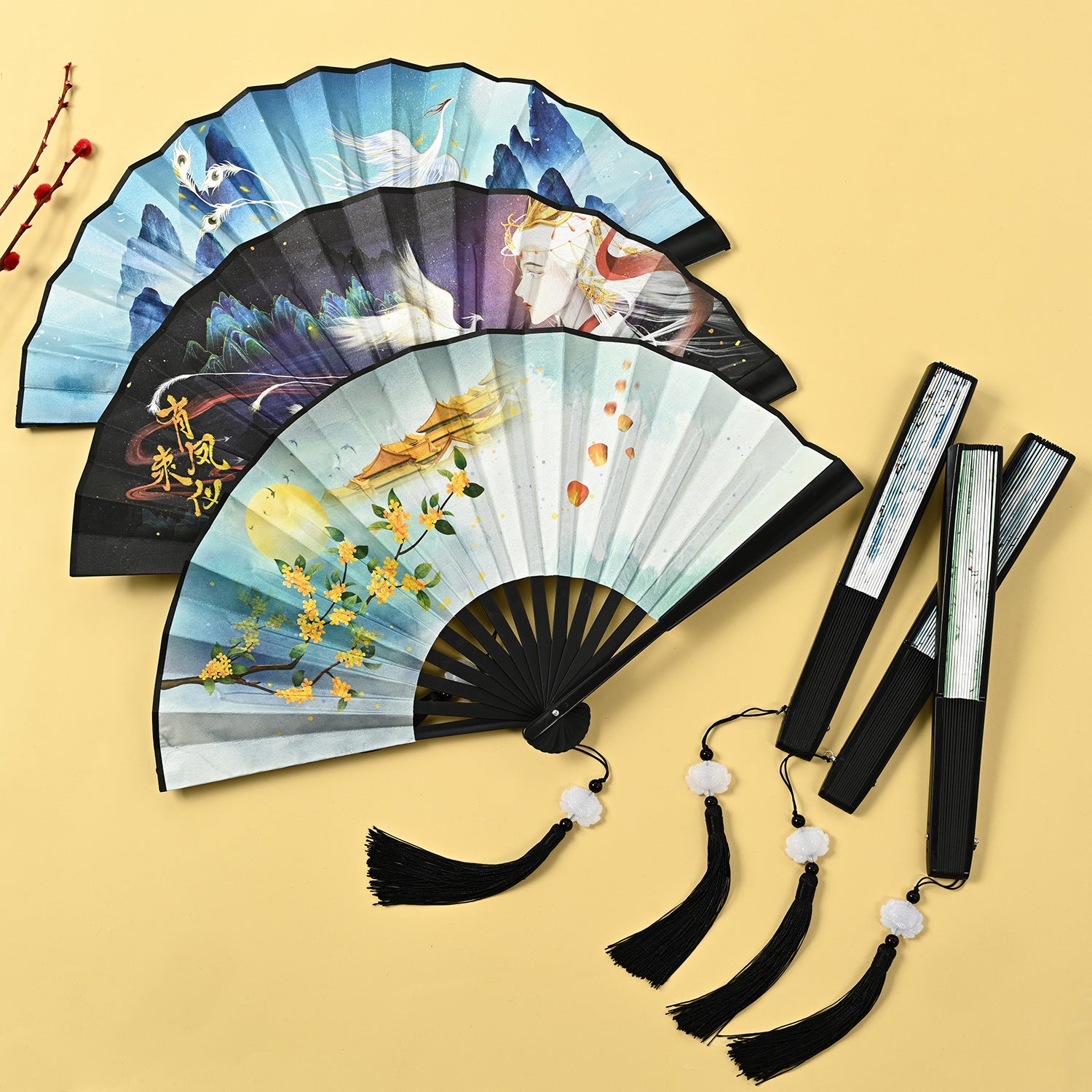 Three open Chinese style folding fans with different nature and mythological designs and black tassels