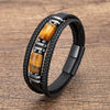 Multi-layer black braided leather bracelet with tiger eye stones and silver accents on wood background