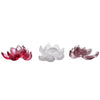 Three small lotus-shaped incense burners in red, white, and purple sitting on a surface.