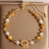 Close up of yellow tiger eye and crystal bracelet with a gourd charm
