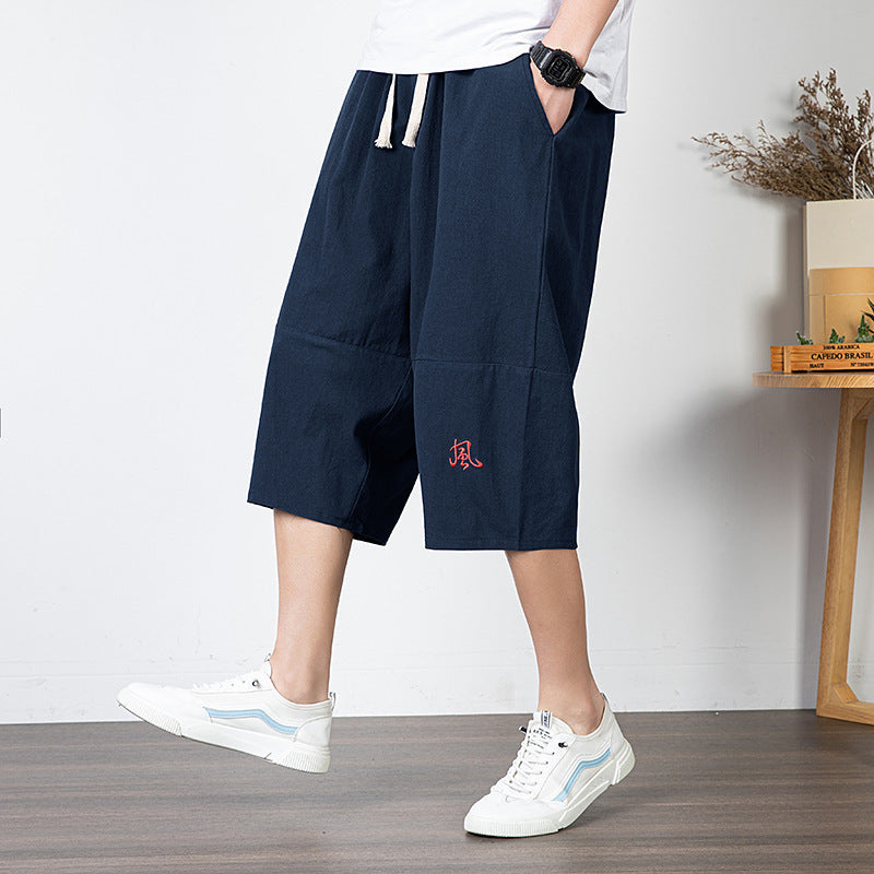 Man wearing navy blue linen capri pants with white sneakers