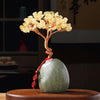 Close up of a handmade crystal tree with purple stones on a ceramic base