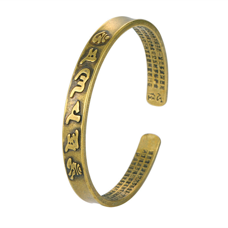 Antique brass cuff bracelet with Tibetan script on the outside and Chinese characters inside