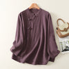 Purple long sleeve shirt with frog buttons hanging on a wooden hanger