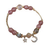 Pink strawberry quartz beaded bracelet with gold tone chain and moon star charms in a box