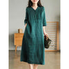 Woman wearing a dark green cotton linen midi dress with a V-neck