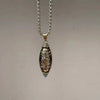 Silver tone rotatable Dzi bead pendant on a box chain necklace