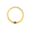 Pale yellow jade bead bracelet with a blue and gold mantra charm on a white background