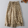 Two pairs of wide leg polka dot pants in black and khaki lying flat