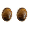Pair of oval tiger eye stud earrings with gold tone metal rims on a white background