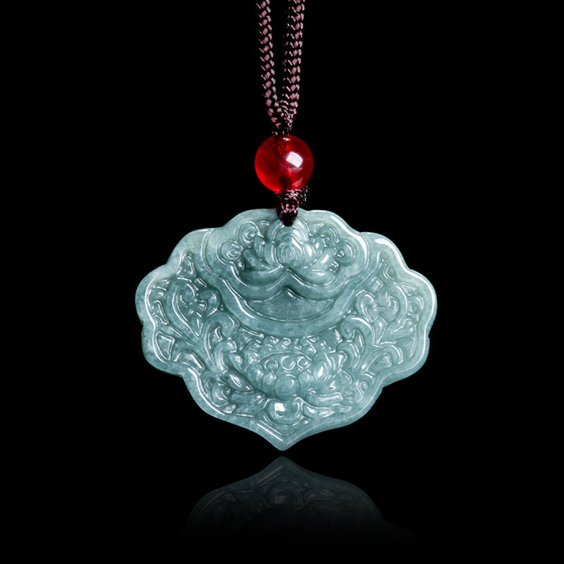 Close up of a carved blue water jade pendant with a lotus flower design on a brown cord