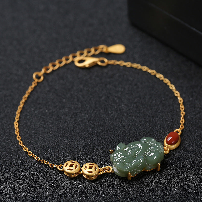 Gold tone chain bracelet with green jade Pixiu charm, copper coins and red agate bead