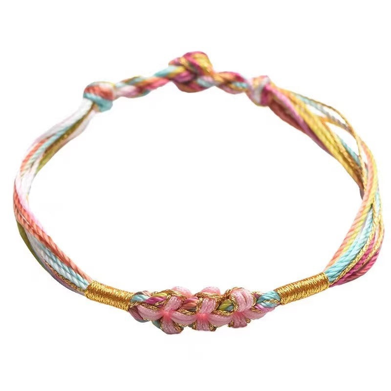 Close-up of a multicolor braided string bracelet with a pink flower knot detail