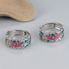 Close up of a silver ring with pink lotus and blue water enamel details