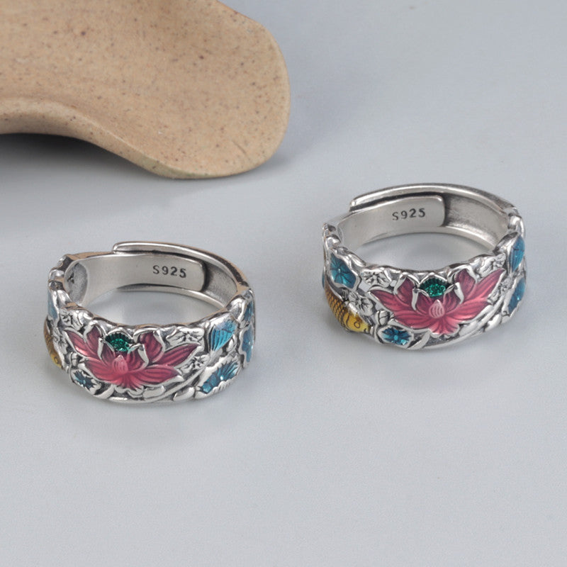 Close up of a silver ring with pink lotus and blue water enamel details