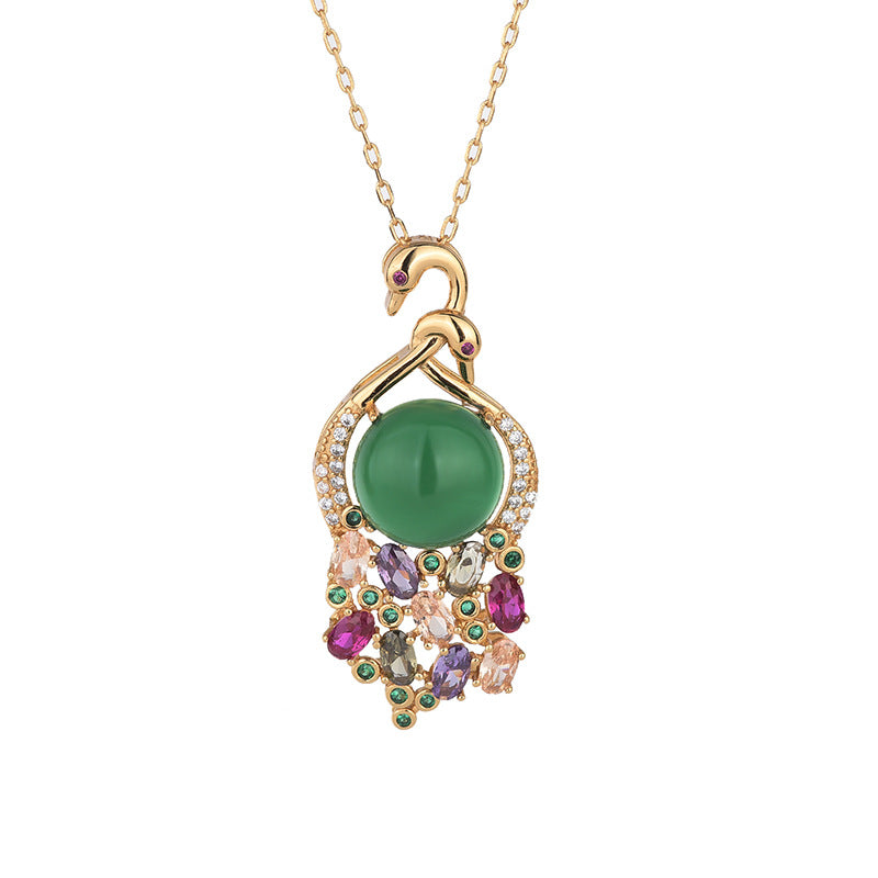 Gold-tone swan necklace with a large green chalcedony stone and multi-colored gems