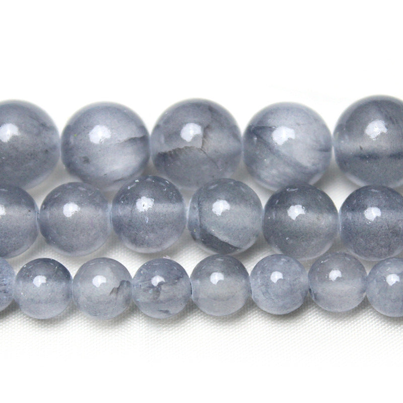 Strands of polished grey ice jade round beads on a white background