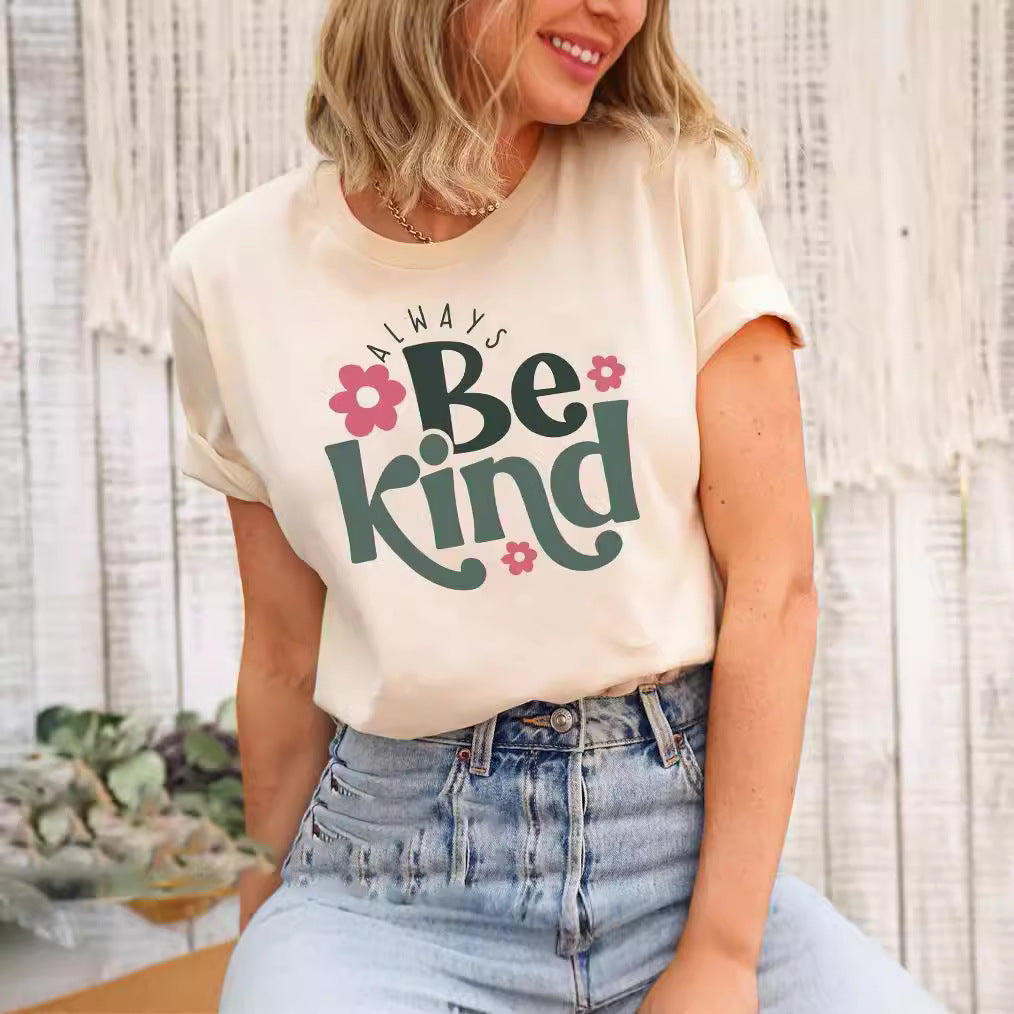 Woman wearing a beige t-shirt with Always Be Kind text and pink flowers
