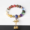 Colorful glass bead wrist mala with gold-tone vajra charm on white background