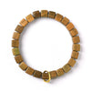 Close up of a green sandalwood bracelet with carved bamboo style beads on a white background