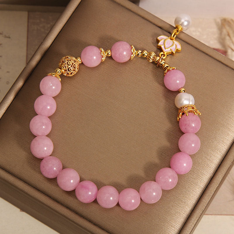 Pink quartzite beaded bracelet with white pearl accents and a gold-tone lotus pendant charm
