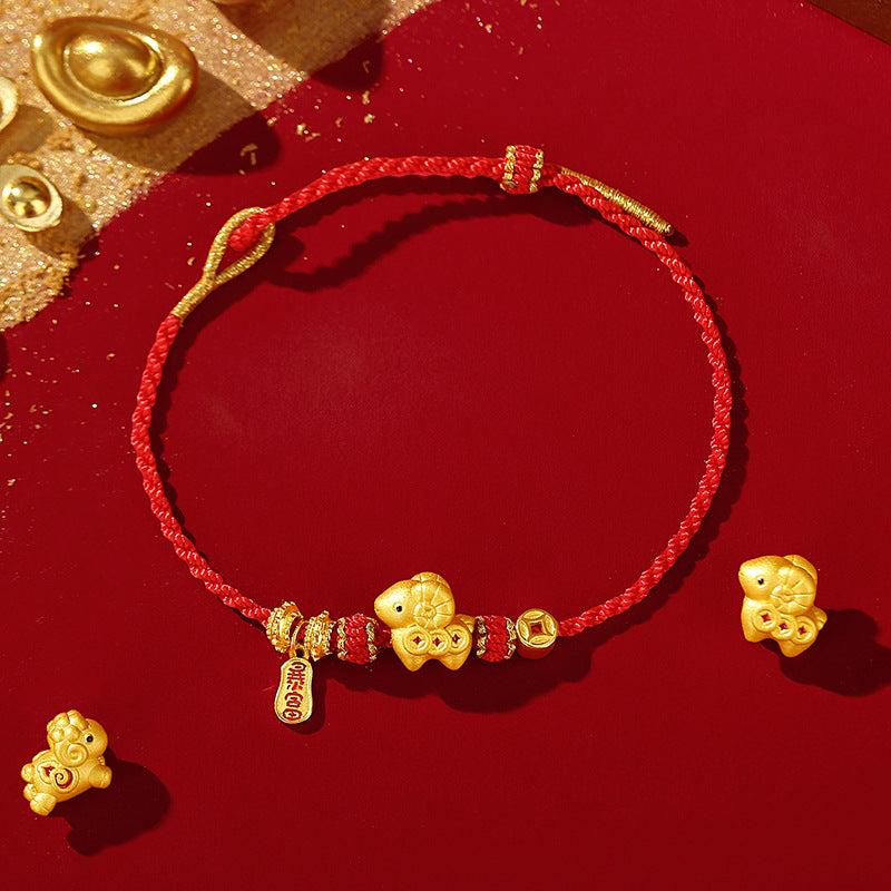 Close up of a red woven bracelet with gold goat charms and silver beads on a red background