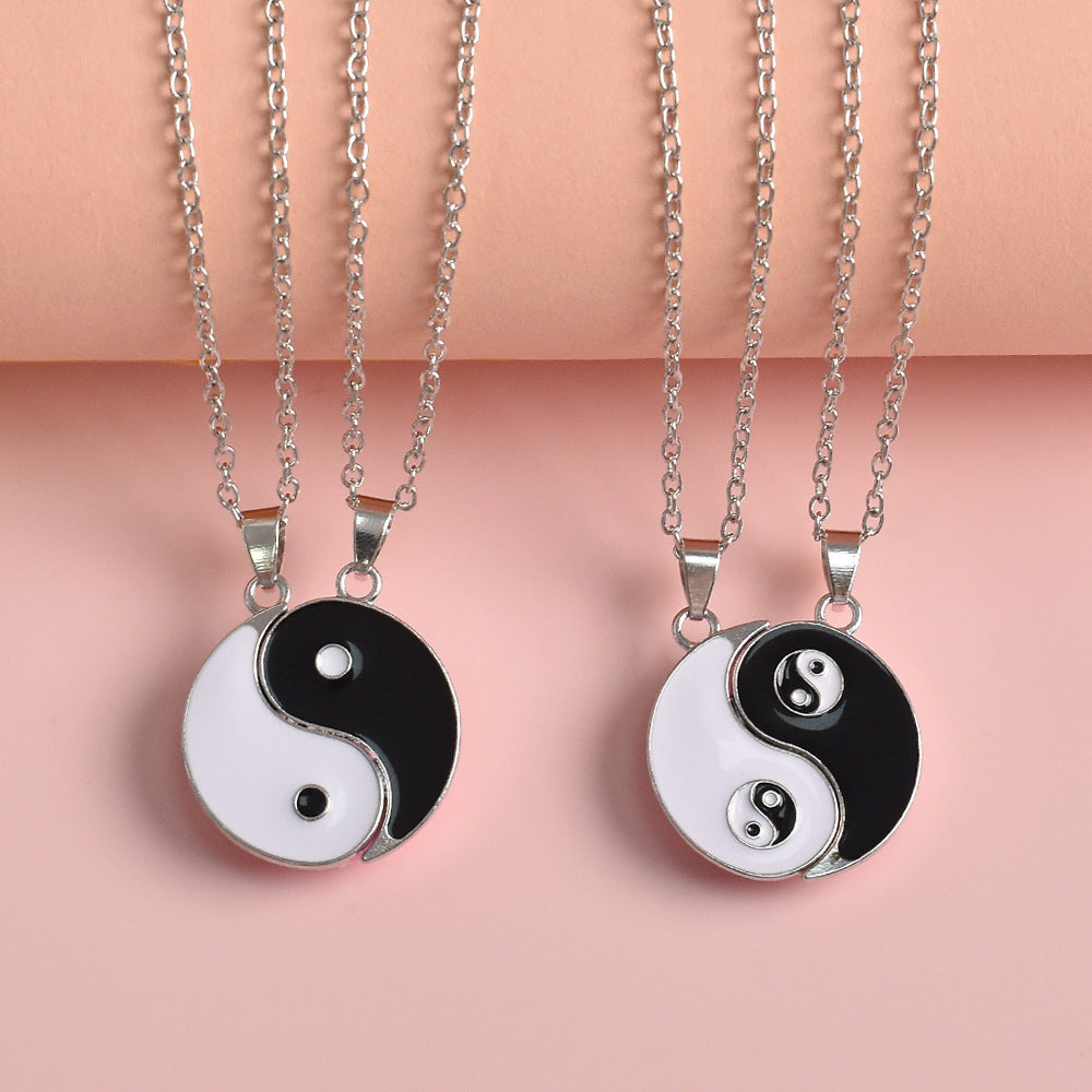 Two silver tone necklaces with black and white Yin Yang pendants that fit together