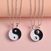 Two silver tone necklaces with black and white Yin Yang pendants that fit together