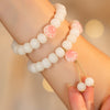 White bodhi seed bracelet with a pink cat paw bead on a wrist