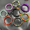 Assortment of colorful jade bead bracelets on a dark surface