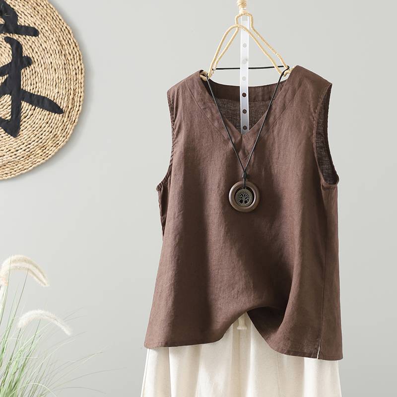 Brown linen sleeveless vest hanging on a wooden hanger against a wall