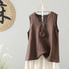 Brown linen sleeveless vest hanging on a wooden hanger against a wall