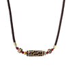 Close-up of a nine-eye dzi bead necklace worn against the collarbone.