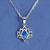 Close up of a silver lotus pendant necklace with a blue stone center