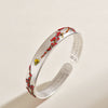 Silver tone open cuff bracelet with red enamel plum blossoms and Heart Sutra engraving inside