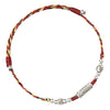 Close up of a colorful braided cord bracelet with silver colored charms on a white background