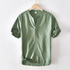 Green men's short sleeve linen shirt with stand collar on a wooden hanger