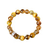 Close-up of a yellow and brown beaded bracelet with crystal accents on a beige background