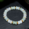 Close up of a white and green jade bracelet with bamboo shaped beads