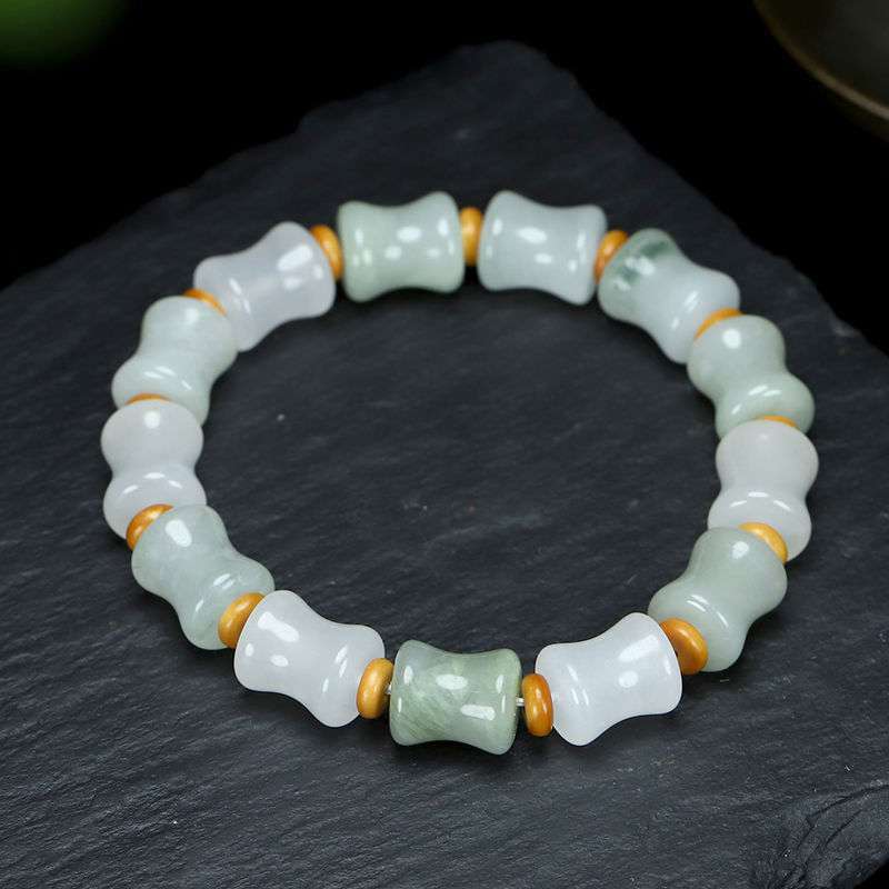 Close up of a white and green jade bracelet with bamboo shaped beads