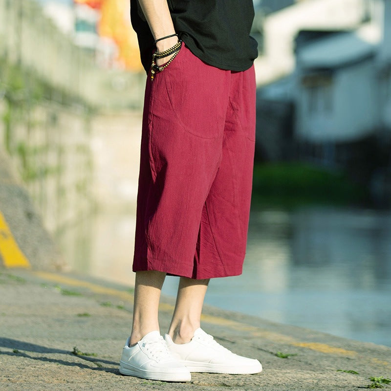 Man wearing red linen cropped pants with drawstring waist standing outdoors
