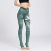 Woman wearing green high-waisted yoga leggings with a large lotus flower print