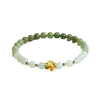 Gradient green and white jade bead bracelet with a gold lotus charm on a white background